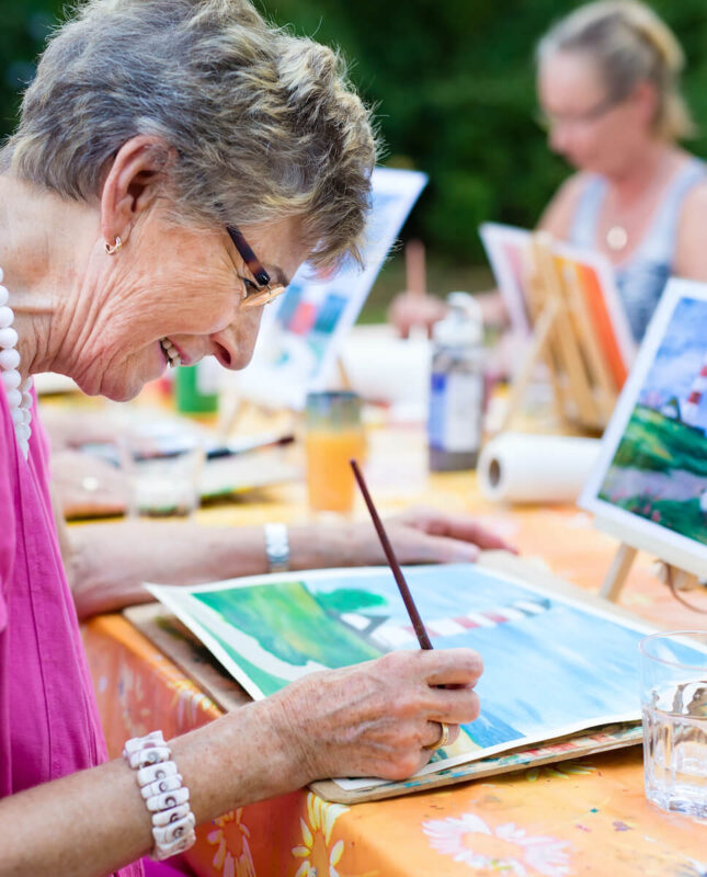 Senior woman painting at a table