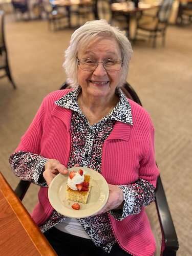 Magnolia Place resident showing off a piece of cake